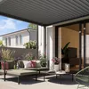 A modern outdoor living space with a pergola, sofa, and coffee table. Anteprima dell’immagine prodotto