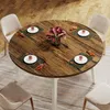 A round dining table set for four people with flowers in the center, placed on a rug in a room with wooden flooring. Náhľad obrázku produktu