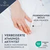 A hand is shown pressing into a white, soft fabric, likely a pillow or duvet cover. Text overlays highlight product features. Produktbild-Vorschau