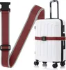 A white suitcase with a red and gray luggage strap attached. Anteprima dell’immagine prodotto