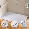 A modern bathroom with a white, stone-look shower tray and wooden floor. Náhľad obrázku produktu