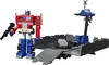 Optimus Prime action figure standing next to his trailer/battle station. Produktbild-Vorschau