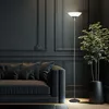 A modern living room with a dark gray tufted sofa and a tall floor lamp. Produktbild-Vorschau