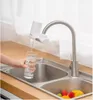 A person is filling a glass with water from a faucet attachment in a kitchen sink. Náhľad obrázku produktu