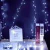 A decorative setup with string lights, a photo frame, and books on a table against a dark blue wall. Produktbild-Vorschau