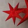 Three red paper star lanterns are hanging against a gray background. Produktbild-Vorschau
