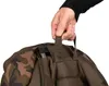A hand is holding a strap on a camouflage-patterned bag. Produktbild-Vorschau