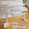 A white adjustable standing desk with dimensions and features highlighted by text overlays. There are also close-up insets of desk accessories. Náhľad obrázku produktu