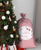 A Christmas sack with a festive design sits next to a decorated Christmas tree. Podgląd zdjęcia produktu