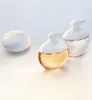 Three white and gold perfume bottles and a soap on a white background. Anteprima dell’immagine prodotto