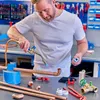 A man is soldering copper pipes in a workshop. Produktbild-Vorschau