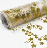 A roll of gold star-patterned fabric on a white background. Produktbild-Vorschau