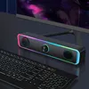 A computer speaker bar with RGB lighting sits on a desk next to a keyboard, in front of a computer monitor. Produktbild-Vorschau