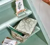 A storage box with a leaf pattern and candles inside, placed on a green wooden staircase. Anteprima dell’immagine prodotto