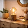 A wooden table with a lamp, a plant, and decorative items. Produktbild-Vorschau