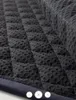 A close-up view of a quilted, dark gray equestrian saddle pad. Produktbild-Vorschau