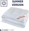 A folded white comforter is shown against a white background. Text overlays indicate it is a 'SUMMER VERSION' and a label on the comforter reads 'CLASSIC'. Voir les images du produit