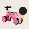 A pink balance bike with leopard print details, shown on a light beige background. A circular inset highlights the texture of the wheels. Náhled obrázku produktu