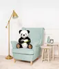A plush panda sits in a light blue armchair next to a floor lamp and two small side tables. Voir les images du produit