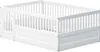 A white wooden children's bed with a door and railing is shown from a side angle against a white background. Produktbild-Vorschau