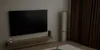 A living room scene with a TV, a floor-standing air conditioner, and curtains. Náhľad obrázku produktu