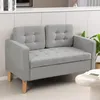 A light gray sofa with tufted cushions and wooden legs is shown in a clean, modern room setting. Náhled obrázku produktu