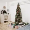 A decorated Christmas tree stands next to a fireplace with presents underneath. Podgląd zdjęcia produktu
