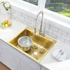 A kitchen sink with a faucet, pot, and dishes. Podgląd zdjęcia produktu