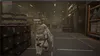 A person in a white suit walks through a warehouse with shelves and boxes. Náhľad obrázku produktu