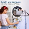 A woman is using a handheld garment steamer on a blue shirt. A circular inset shows a garment steamer and other travel items packed in a suitcase. Náhled obrázku produktu