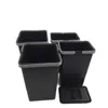 Four black trash bins with gray rims are arranged on a white background. One bin has its lid placed in front of it. Voir les images du produit