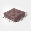 A square brown floor cushion with tufted detailing is shown from a slightly elevated side angle against a plain light gray background. Dimensions are indicated with arrows and text. Náhled obrázku produktu