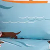 A close-up view of a blue duvet cover with a cartoon dachshund pattern, showing waves and a dog. Podgląd zdjęcia produktu