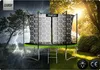 A trampoline is shown in two contrasting environments: a stormy, dark setting with lightning and a sunny, outdoor garden setting. Produktbild-Vorschau