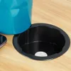 A close-up view of a blue cup placed in a black circular holder on a wooden surface. Produktbild-Vorschau