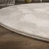 Close-up of a fluffy white rug on a wooden floor. Produktbild-Vorschau
