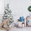 A decorated artificial Christmas tree with a rocking horse and gifts in a room. Produktbild-Vorschau