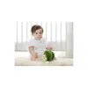 A baby sitting on a fluffy rug next to a crib, playing with a stuffed caterpillar toy. Produktbild-Vorschau