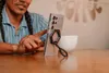 A person is using a smartphone with a magnetic ring stand attached. Produktbild-Vorschau