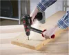 A person is using a cordless drill to drill a hole in a wooden plank. Produktbild-Vorschau