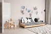 A child's bedroom with a daybed, small table and chair, and wall decorations. Anteprima dell’immagine prodotto
