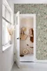 A hallway with a door open to a room, decorated with floral wallpaper. Produktbild-Vorschau
