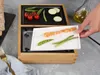 A hand is placing a plate of food onto a grill. Produktbild-Vorschau