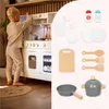 A child playing with a toy kitchen and various kitchen accessories. Produktbild-Vorschau