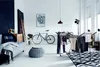 A modern, minimalist living space with a drying rack, bicycle, and sofa. Produktbild-Vorschau