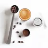A flat lay of coffee-related items including a scoop of coffee beans, a glass of espresso, and coffee capsule components. Produktbild-Vorschau