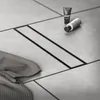 A close-up view of a modern shower drain with bathroom accessories on a tiled floor. Náhľad obrázku produktu