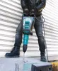 A person is using a Makita demolition hammer on a concrete surface. Anteprima dell’immagine prodotto