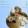 Cubes of resin with embedded objects, surrounded by empty resin molds and containers of materials. Voir les images du produit
