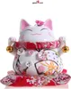 A Maneki-Neko (Japanese lucky cat) figurine, decorated with floral patterns and bells, is presented against a white background. Podgląd zdjęcia produktu